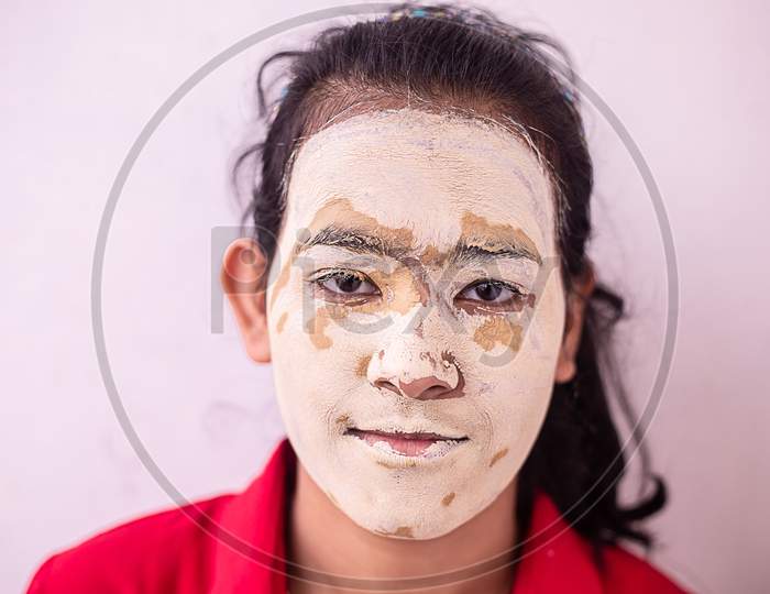 Young Brunette Girl With Ayurvedic Natural Hearbal Cosmetic Facial Mask Applied Over Her Face. Multani Mitti / Fuller Earth Clay Pack