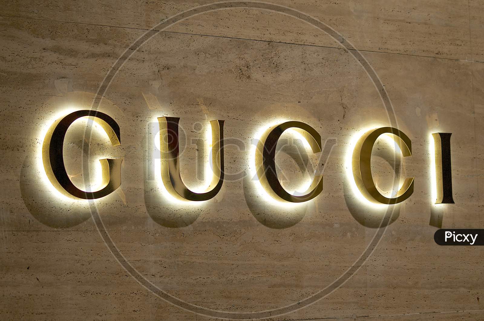 Illuminated Gucci Sign On A Marble Stone Wall