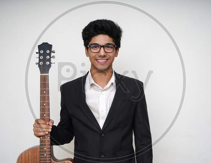 Young Handsome Asian Boy Wearing Formal And Specs Holding A Guitar