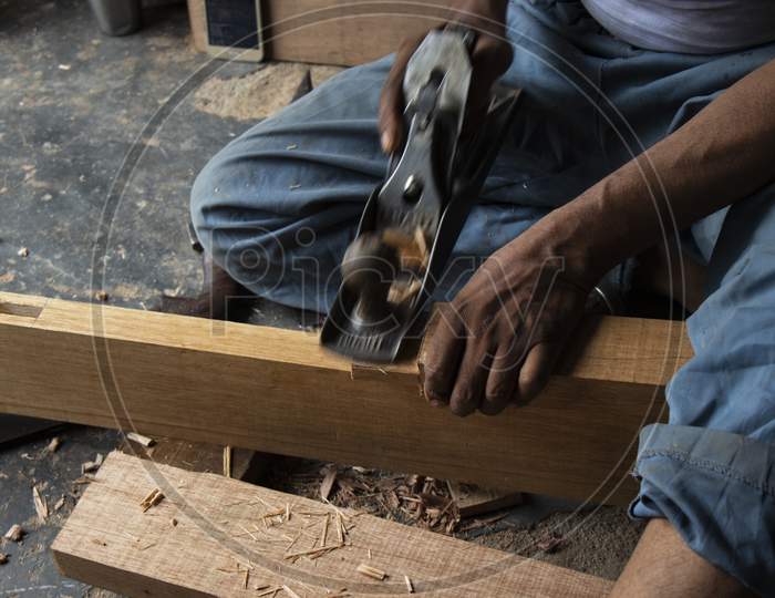 Carpenter Working With Gouge On Table In His Workshop