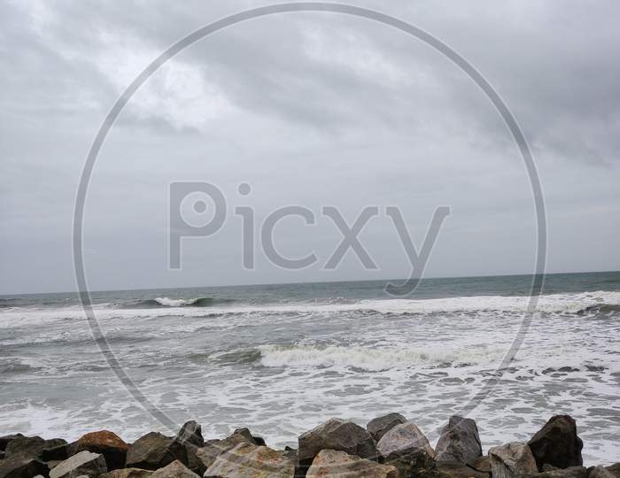 A Picture Of Beach With Rocks On The Shore And Cloudy Sky On Background. The Sea Is Violent With Strong Waves In This Picture. Kappil Beach (Varkala Town), Kerala.