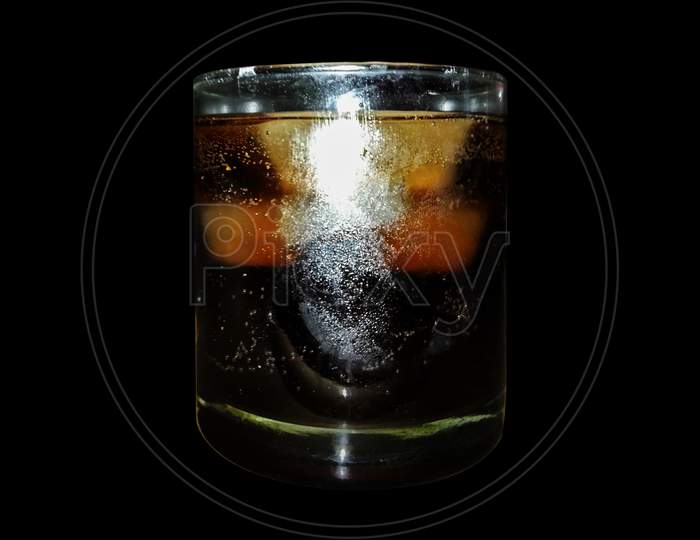 Whiskey in glass with ice cubes close-up view
