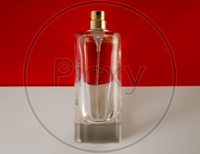 Perfume bottle isolated against white and red background.