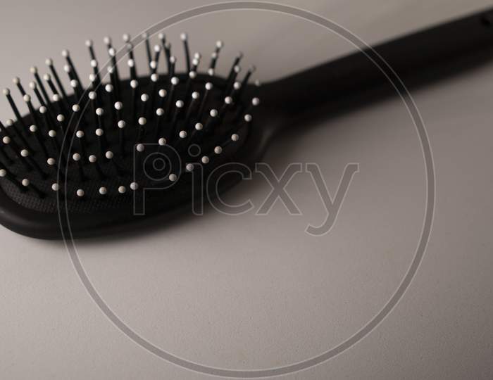 black hair brush against a white background