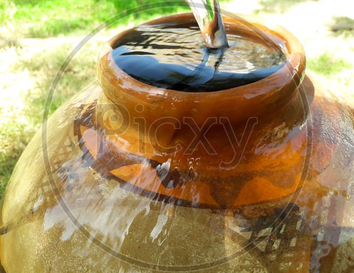 Filling Water In A Clay Pot Overflowing In Summer During Lack Of Water In Rural Areas