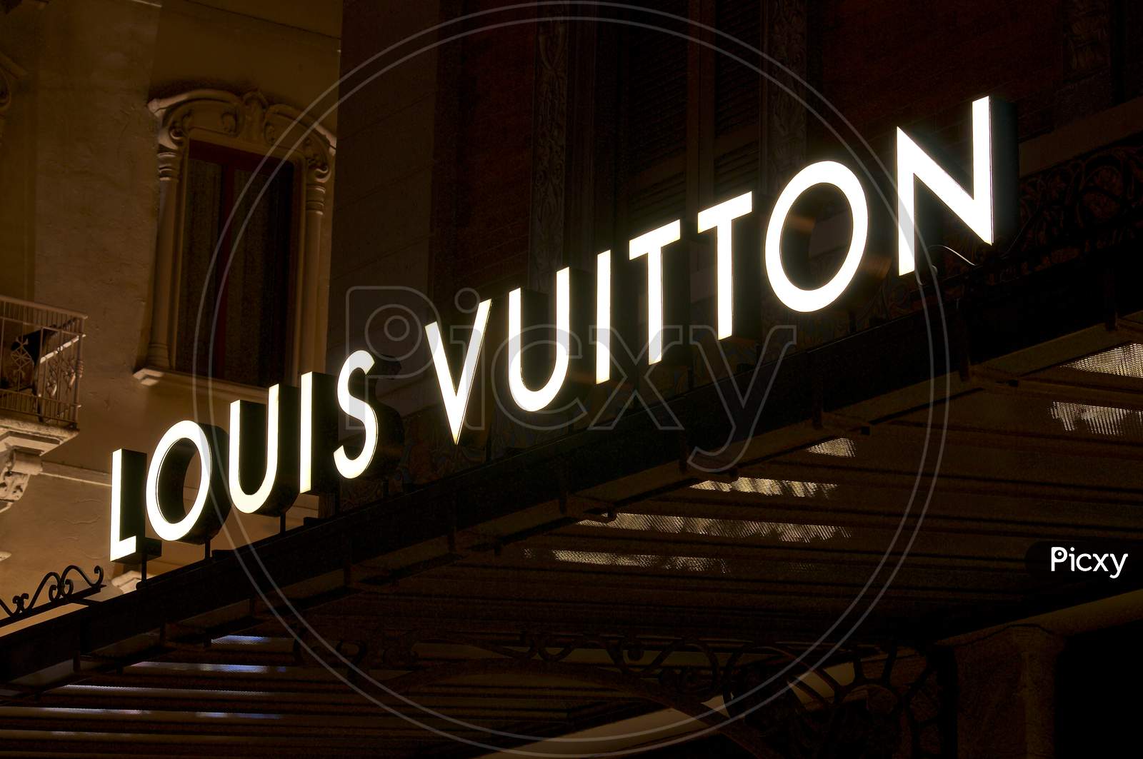 Street Signage Board with Louis Vuitton Logo in the Evening