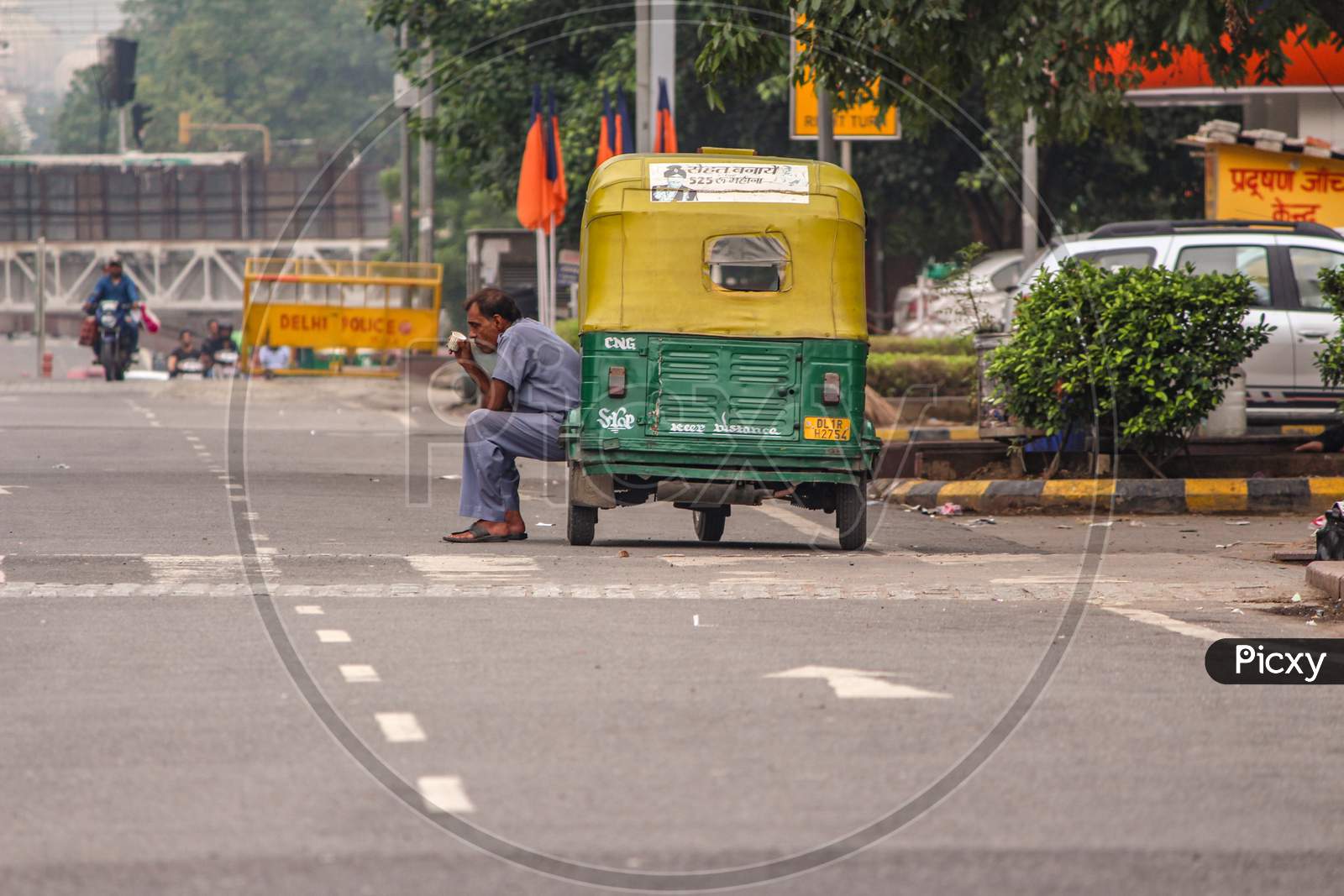 New Delhi, Delhi/ India - June 9 2020: A Auto Rickshaw Driver Sitting Outside His Auto In The Hot Weather In Delhi