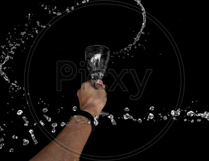 A Round Splash Of Water Through Wine Glass