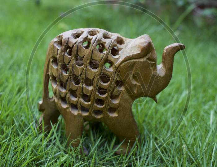 An Exquisite Elephant Within Another Elephant Made Of Kadamb Wood With Intricate Carving, Handcrafted By Artisans Of Rajasthan In India On Outdoor Background Of Green Grass. Baby Elephant Is Carved Inside.