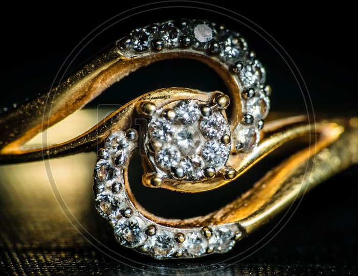 Macro Shot Of A Golden Diamond Ring In A Dark Background