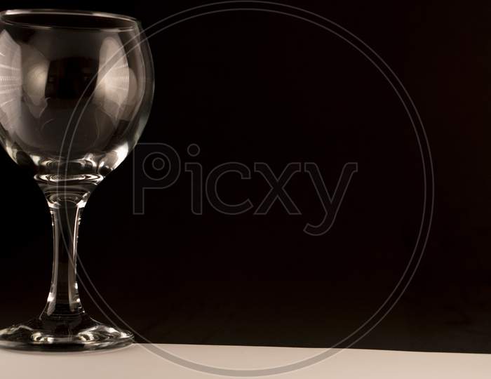 picture of empty wine glass on a black background and empty space for text.