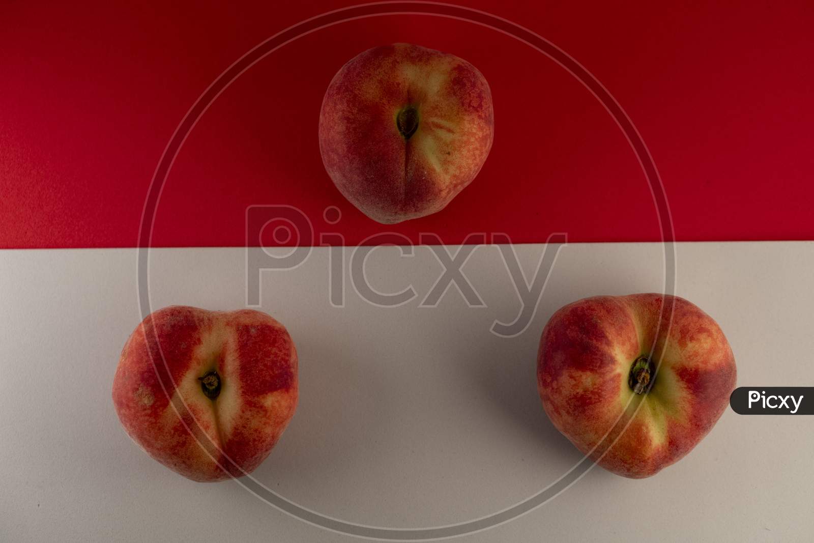 Juicy red peach on a red and white background. Photo has empty space for text.
