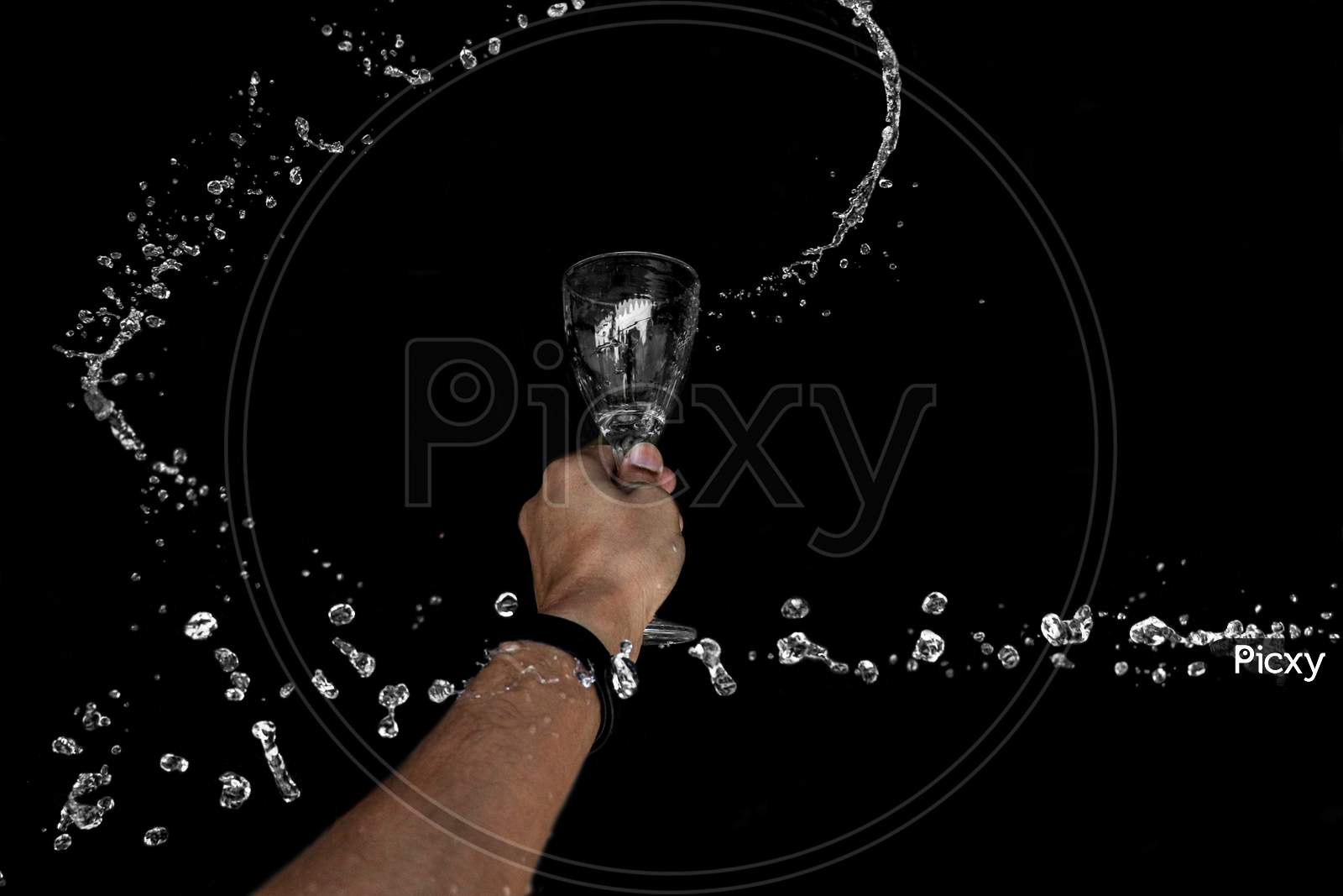 A Round Splash Of Water Through Wine Glass