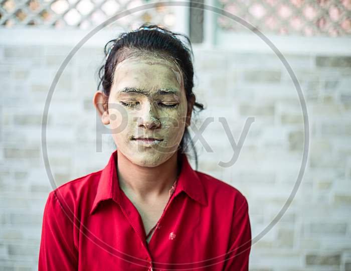 Young Brunette Girl With Ayurvedic Natural Hearbal Cosmetic Facial Mask Applied Over Her Face. Multani Mitti/Fuller Earth Clay Pack