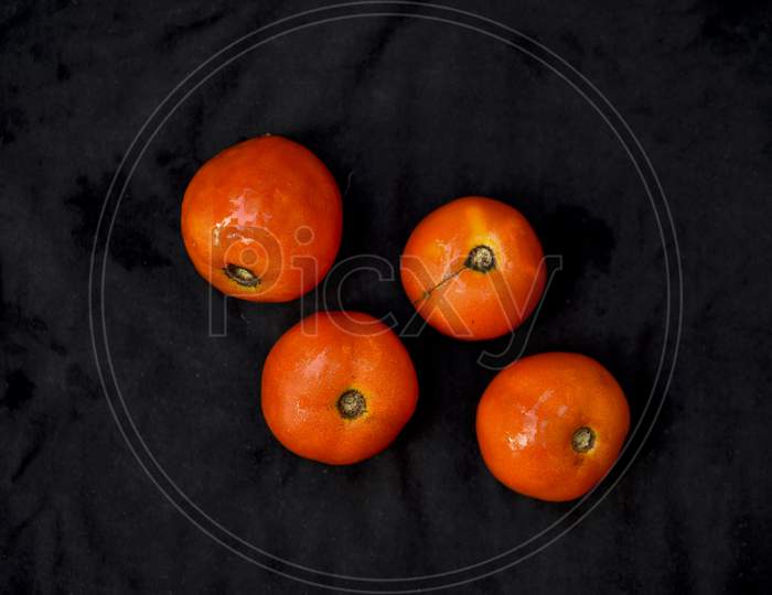 Red, ripe tomatoes on a dark background. Harvesting tomatoes. Top view