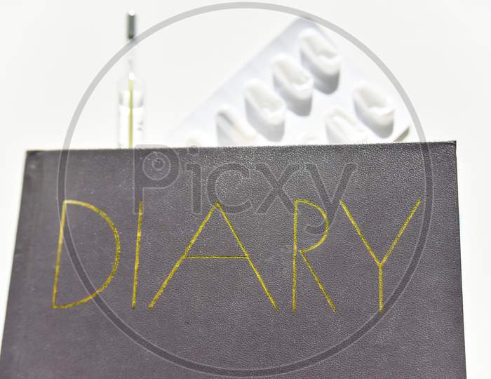 Selective Focus Of The Diary With Thermometer And Pills On The Background
