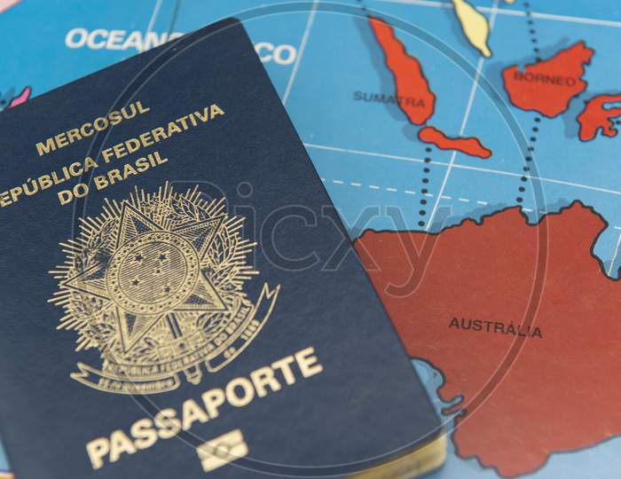 Top View Of Brazilian Passport Over Map. Focus On The Continent Oceania. Emigration, Travel, Destination Concept.