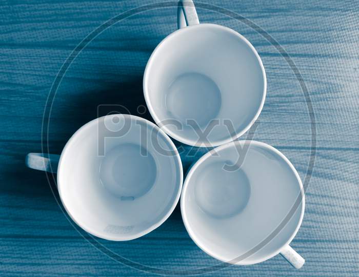 Three coffee mugs arranged in a creative way to make a wallpaper or background with adequate space for text.