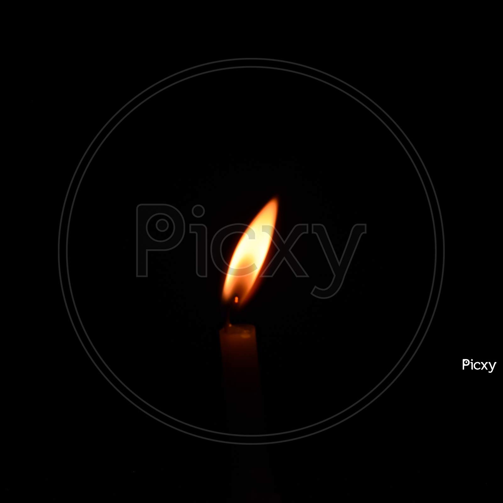 Burning candle on black background, Candle in the dark