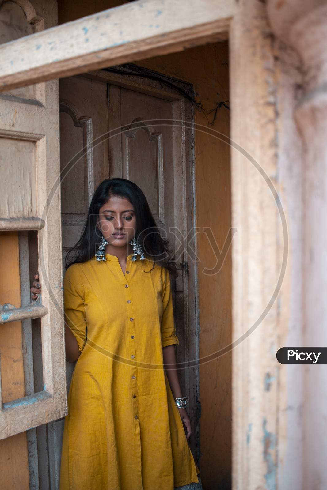 Image of A Beautiful Asian Girl Sitting On The Window Wearing