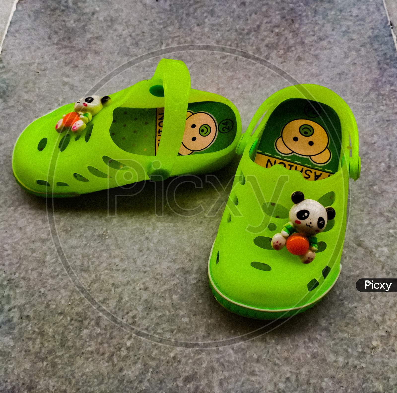 A vibrant green coloured pair of footwear of a baby.