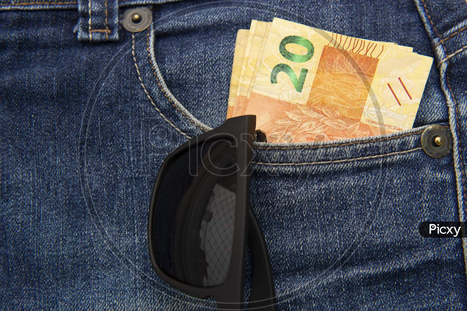 Close Up Of Several 20 Reais Bills In The Pants Pocket. Sunglasses Hanging In The Pocket. Money In Pocket Concept. Money-Rich Person Or Money To Spare.