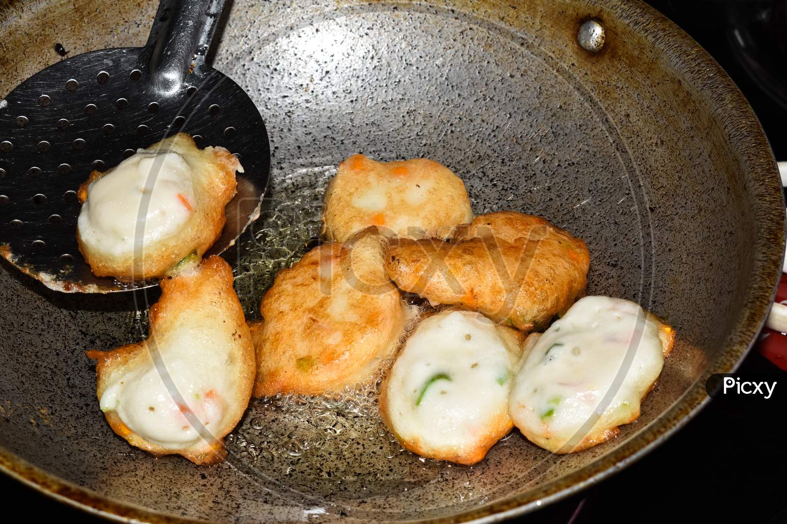 South Indian Cuisine - Vada Or Medu Vadai Frying In Coconut Oil. Very Popular South Indian Snack.