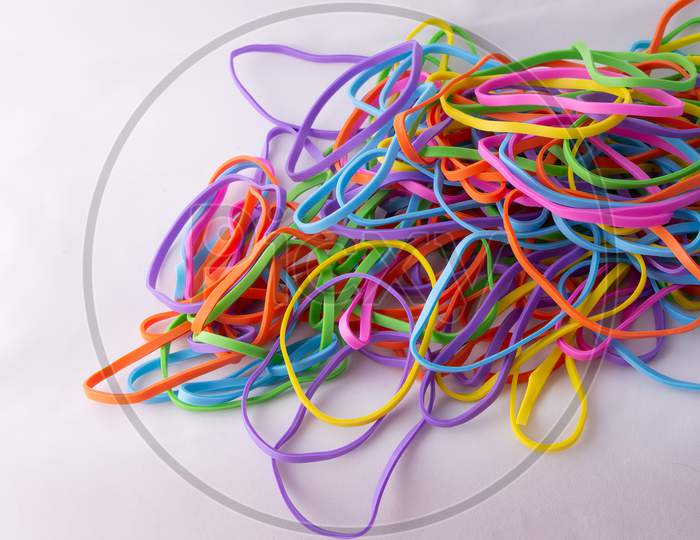 Bright neon rainbow rubber bands pile close up
