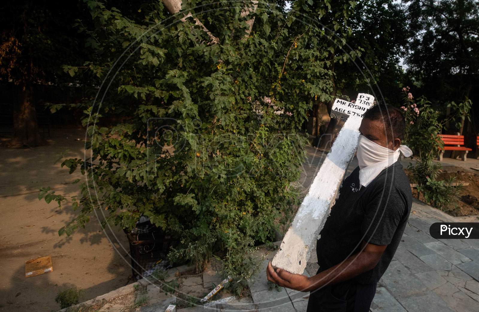 A Cemetery Worker Carries A Cross  At Mangolpuri Cemetery Amid The Covid-19 Pandemic On July 1, 2020 In New Delhi, India.