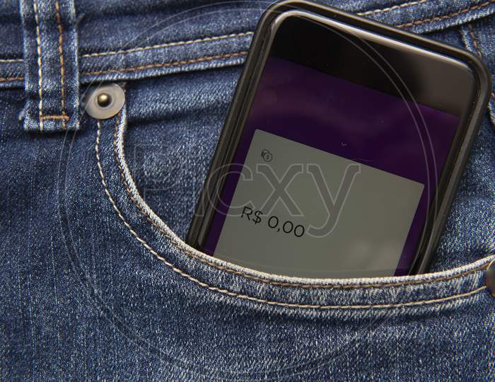 Close Up Of Cellphone In Pants Pocket Showing Screen With Zero Money Balance. Concept Of Being Economically Broken. Virtual Money In Your Pocket.