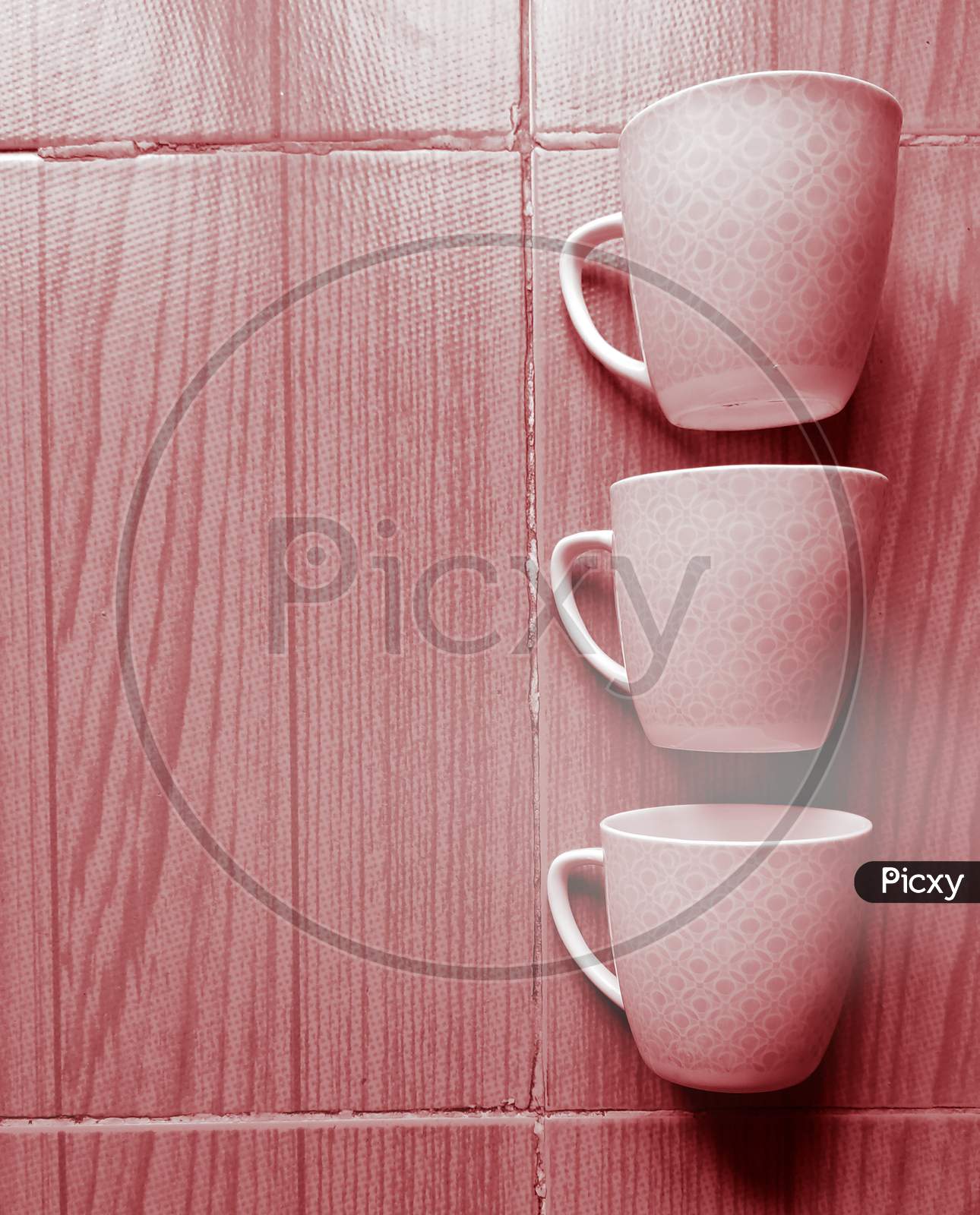 Three coffee mugs arranged in a creative way to make a wallpaper or background with adequate space for text.