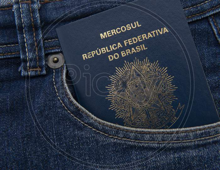 Brazilian Passport In Jeans Pocket With Real Notes. International Travel And Tourism Concept. Business Trip.Translate: Mercosur - Federative Republic Of Brazil. Old Blue Passport.