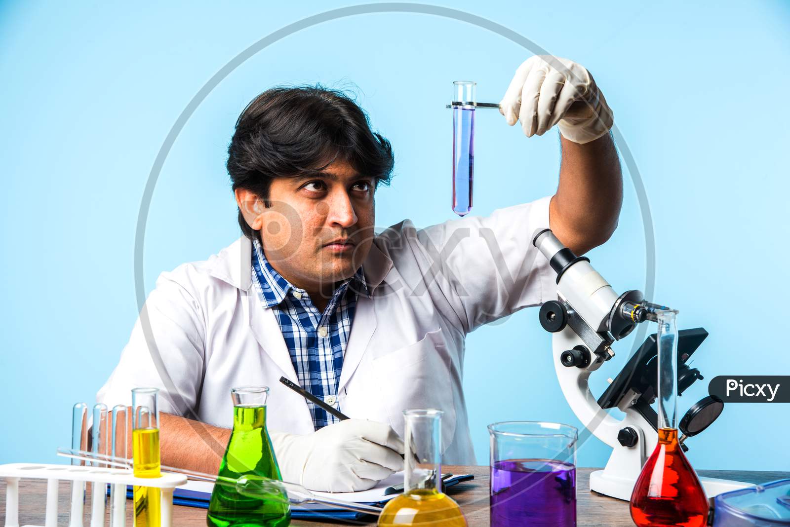 Indian male scientist or doctor or science student experimenting
