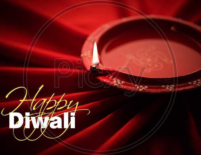 Big Diwali diya over silk cloth - happy diwali greeting card