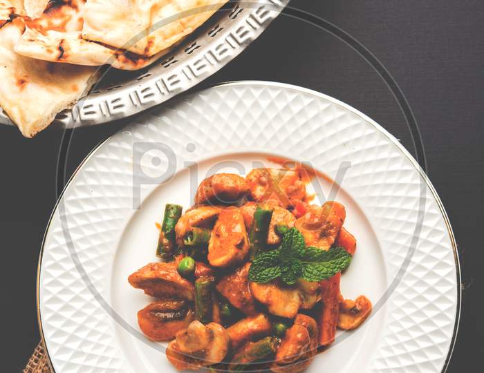 Mushroom Masala Fry served with Naan, selective focus