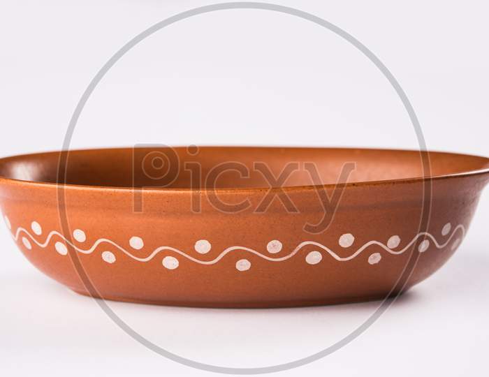 Empty terracotta serving bowl or brown clay soup bowl isolated on white