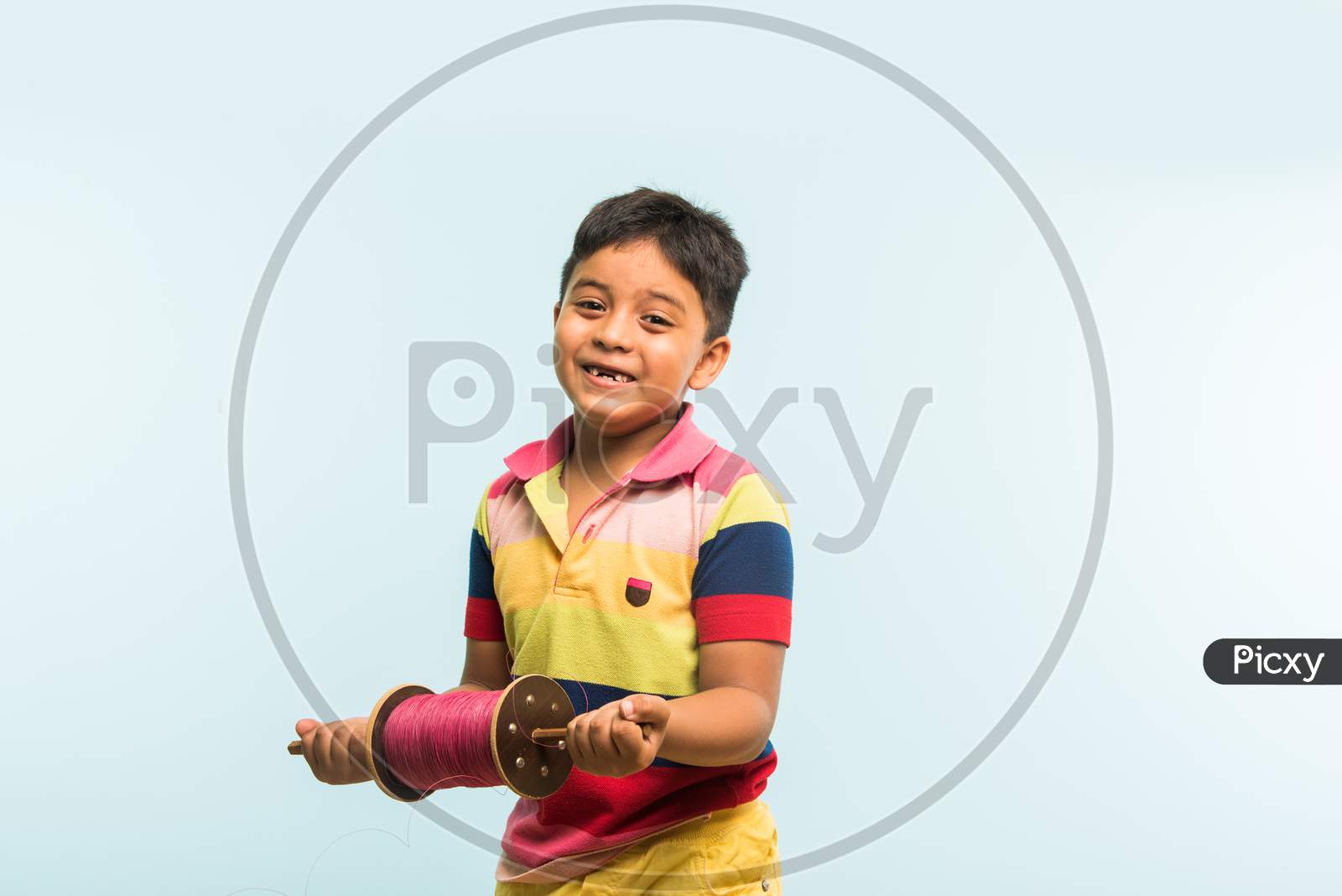 Indian boy holding fikri / spindal / reel on makar sankranti