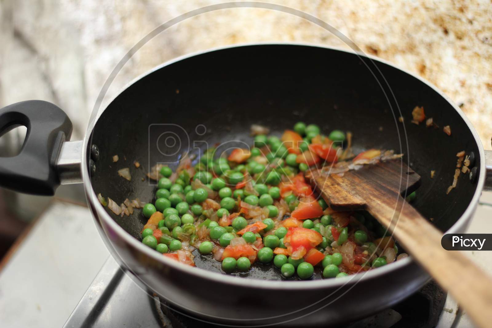 Cooking vegetables peas in a fry pan.