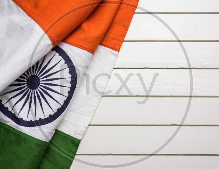 Indian flag with folds over wooden table