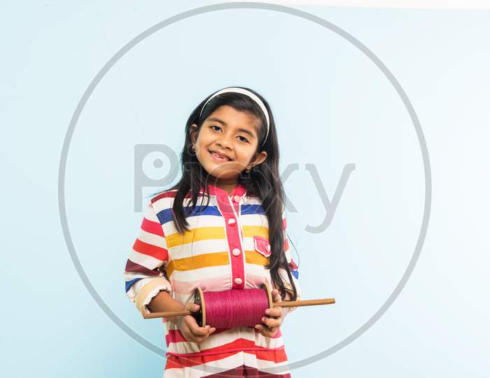 Indian girl holding fikri / spindal / reel on makar sankranti