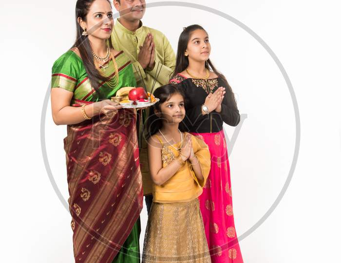Indian family performing Gudi Padwa puja or ugadi puja with puja thali