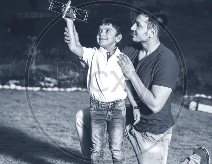 Indian father and son with toy plane, outdoor