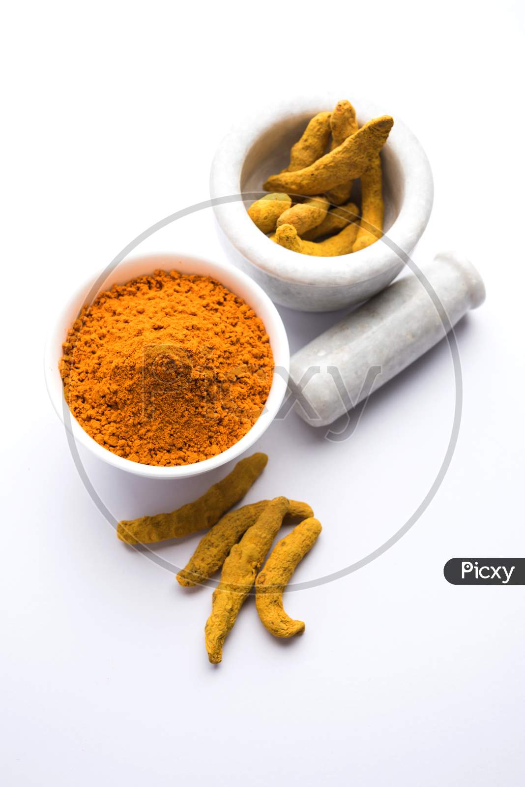 Turmeric or Haldi powder in bowl over colourful background