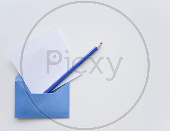 Selective Focus, White Paper Sheet And Blue Pencil Out Of The Blue Envelope