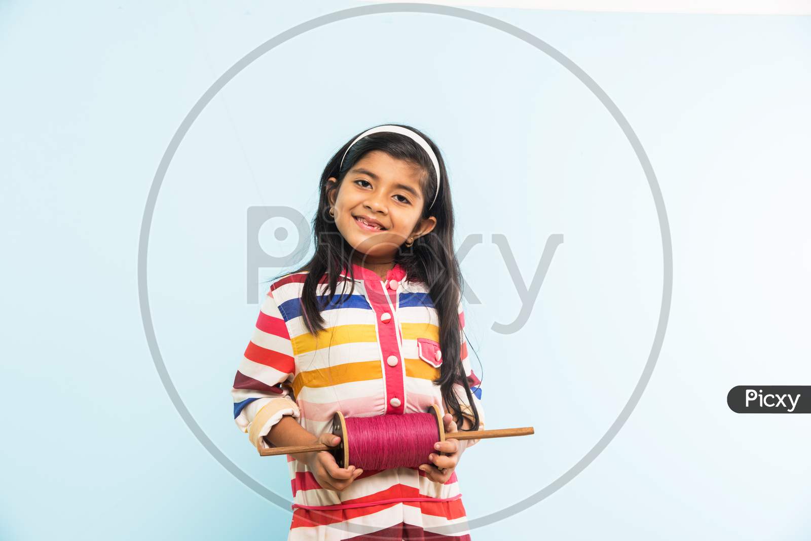 Indian girl holding fikri / spindal / reel on makar sankranti