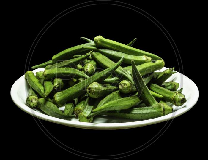 Green Lady Finger on White plate Isolated background