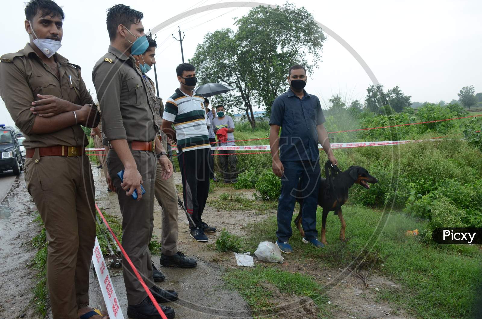 Police officials accompanied by a police dog at the site of the encounter of gangster Vikas Dubey who was killed when he tried to escape from police custody in Kanpur, Uttar Pradesh on July 10, 2020