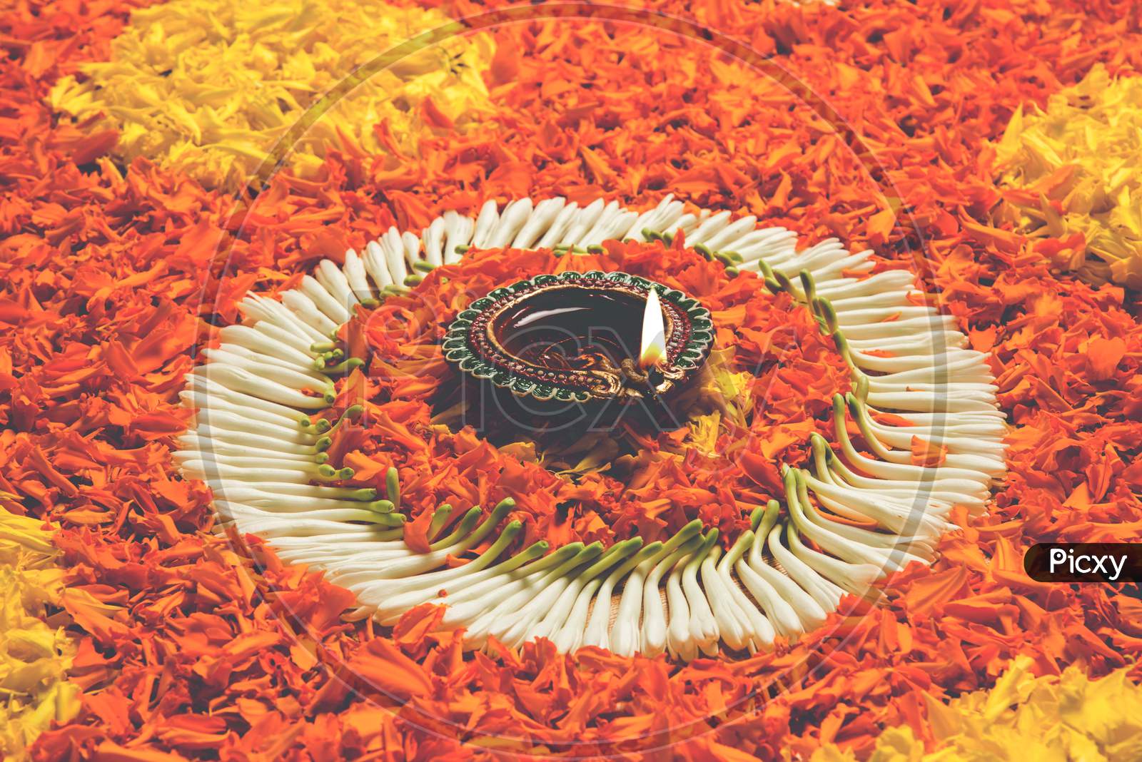 flower rangoli for Diwali or pongal with diya or clay oil lamp