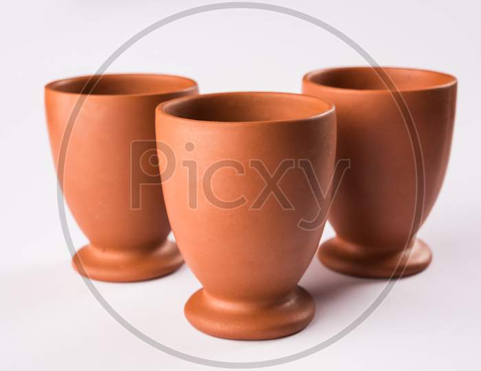 Empty terracotta mug or brown clay coffee cup or jar or drinking glass, isolated over white
