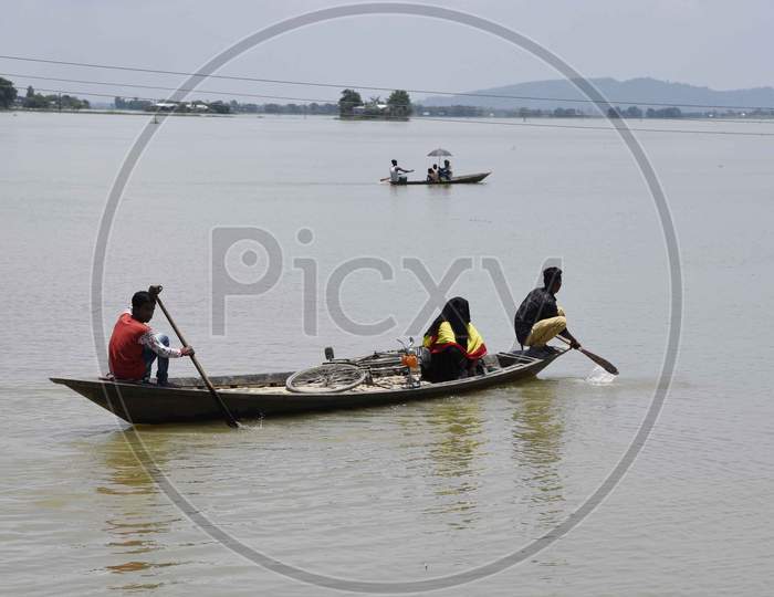 Villagers cross a flooded area on a boat